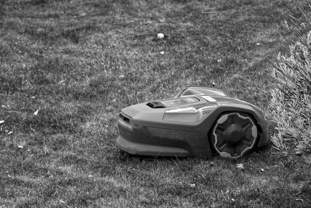 Rasenmäher Roboter mit Solarenergie nutzen und Stromkosten sparen Rasenmäher Roboter im Garten mit Solarpanelen für nachhaltige Energieversorgung